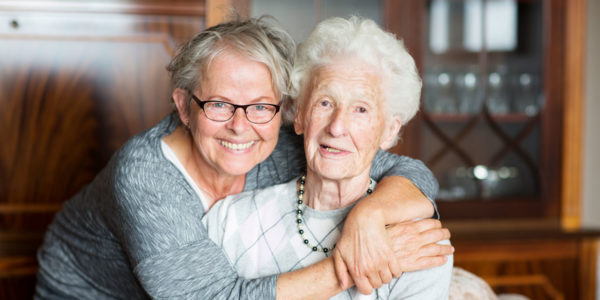 Woman hugging senior lady